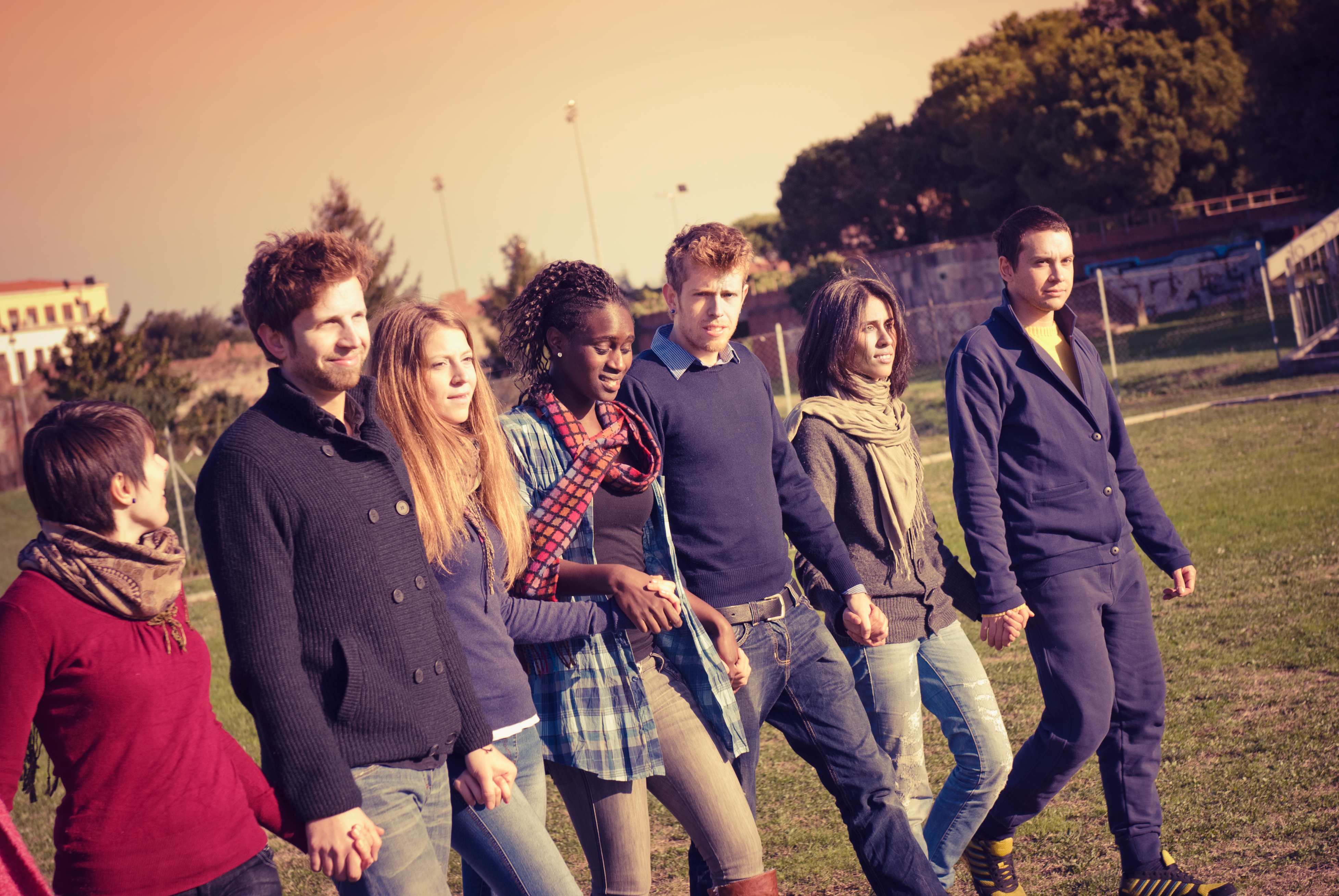 Young adult student outdoors holding hands and walking