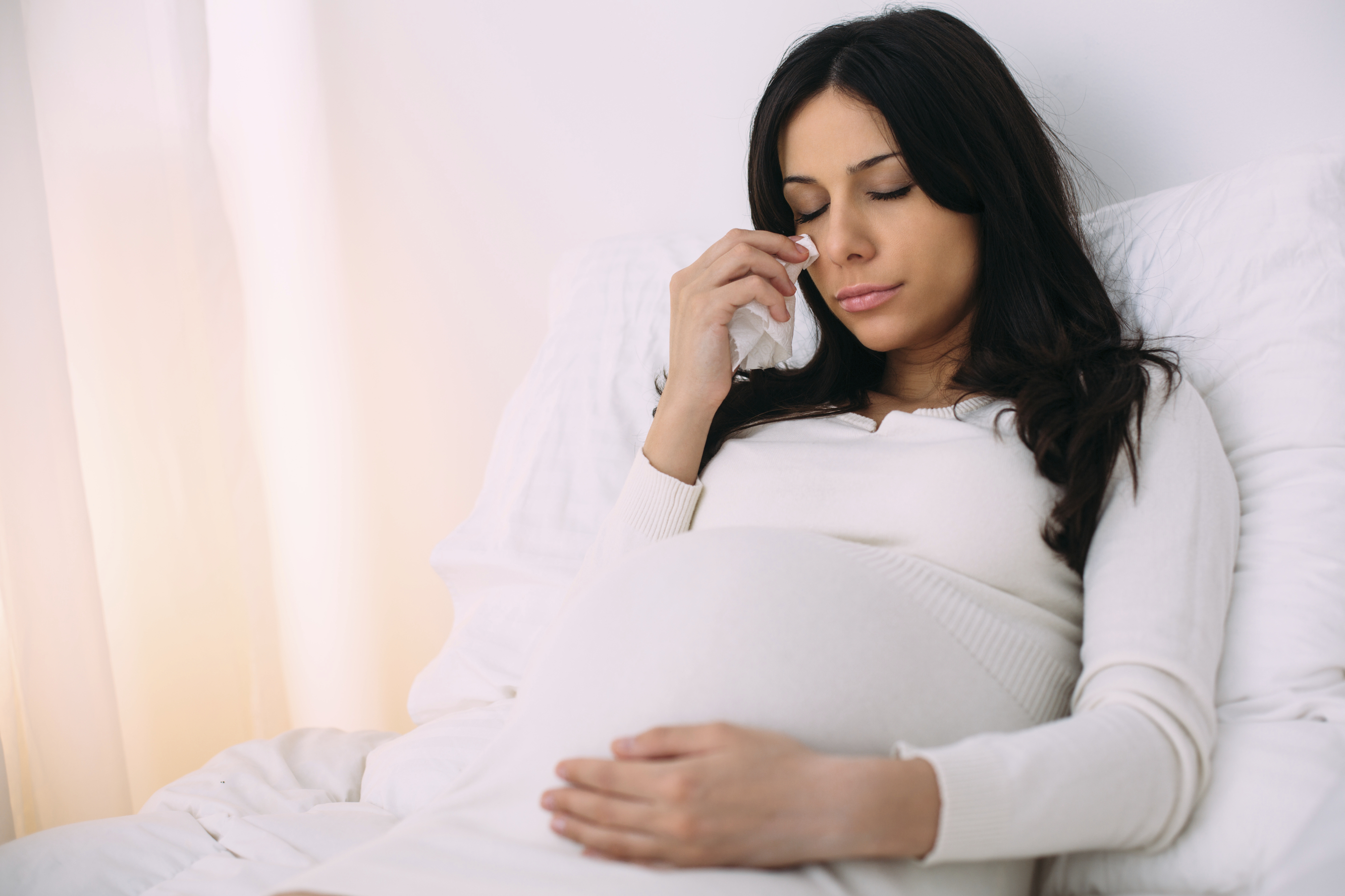 Beautiful female laying in bedroom and crying